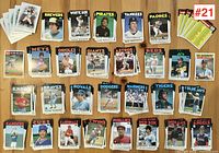 Image showing a selection of 38 1985 Topps baseball cards laid out on a wood surface, showcasing players from various MLB teams.
