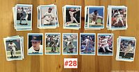 Wide view of multiple stacks of baseball cards spread out on table showing player images and card fronts