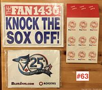 Three items including 'The Fan 1430 Knock the Sox Off!' sign, Blue Jays 25th season flag, and autographed King Donuts box.
