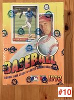 Sealed box of 1992 O-Pee-Chee baseball bubble gum cards on wooden surface with player images and MLB logos.