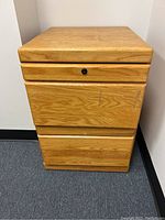 Front view of the wooden 2-drawer filing cabinet showing the drawers and lock on the top drawer.