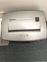 Close-up of the top of the silver Fellowes P560-2 paper shredder showing the feed slot and power button.
