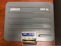 Photo of Pelouze heavy duty utility scale showing top surface and readable label indicating 100 lb capacity.