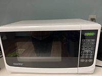 Front view of the white Danby microwave oven with digital control panel and viewing window.