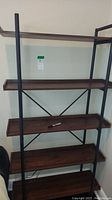 Front view of the 5-tier bookcase showing metal frame and dark faux wood shelves with metal cross braces at the back.