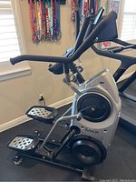 Side view showing foot pedals, frame, flywheel housing