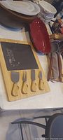 Overview showing cheese board set alongside multiple serving bowls and kitchen utensils