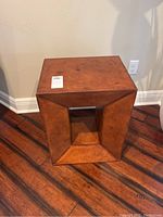 Full view of faux leather accent side table showing hollow center and visible stitching on warm brown leather finish.