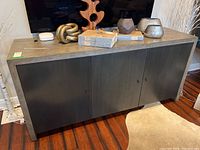 Front view of the 3 door wall credenza showing the dark front panel doors with round knobs and the wood finish frame.