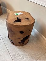 Front angle of one wood trunk table showing natural hollows on top and side.