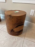 Front view of cylindrical wood trunk table showing natural knots and grain.