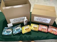 Two cardboard cases labeled "Hoover #974A00009 Paws & Claws Spot Cleaner Premix 36 - 6 fl oz bottles" with one bottle out of the case visible. Six boxed Youmop toilet bowl spray products placed in front of the cases.