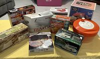 Various boxed kitchen and household items, including s'mores maker, egg cooker, and hair dryer, arranged on floor