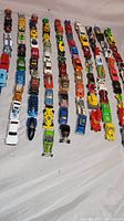 Rows of 100 vintage 1/64 scale die-cast cars including Hot Wheels, Matchbox, and Corgi.