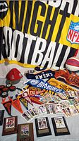 Photo showing NFL Monday Night Football flag, collegiate pennants, baseball cards, basketball, hockey pucks, and jerseys.