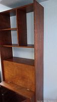 Front angled view of MCM Danish hutch showcasing multiple shelves and fold-down cabinet closed.