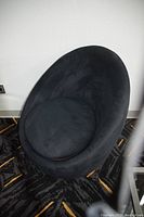 Front angle view of black egg chair showing plush fabric seat cushion and curved backrest.