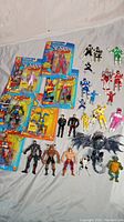 Full lot view showing packaged X-Men figures on left and loose Power Rangers, Spawn, TMNT, and alien figures on right