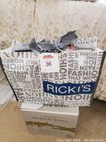 Bag with printed text and ribbon handles containing CDs