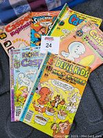 Six vintage comic books arranged with front covers visible, showing colorful classic illustrations and titles such as Casper, Richie Rich, Devil Kids, and Superman.
