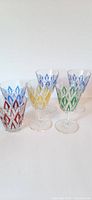 Front view of six vintage glasses including tumblers and wine glasses highlighting the colored diamond pattern