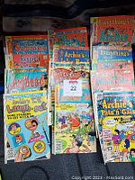 Photo showing full collection of 13 vintage Archie comic books including Sabrina, Jughead, Reggie, Everything's Archie, and others.