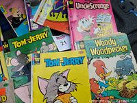 Top view of the collection showing covers of Tom and Jerry, Uncle Scrooge, and Woody Woodpecker comic books