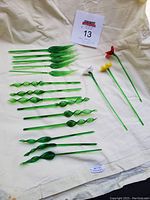 Overview photo of green leaf and grass styled swizzle sticks and three flower top swizzle sticks.
