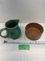 Photo showing green McCoy pitcher jug and brown McCoy bowl side by side with measuring tape in front indicating 7 inch size.
