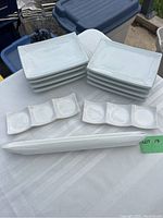Set of white ceramic serving dishes including 8 rectangular plates, 2 three-compartment dipping trays, and 1 long slender olive server.