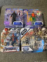 Four sealed toys in original packaging: Space Jam LeBron James Cyber Hero, another Space Jam character, Marvel Avengers Iron Spider, and Star Wars Mission Fleet set.