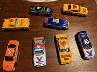 Top-down view of the lot showing eight 1/64 scale diecast racing cars including Kodak, Polaroid, Valvoline branding.