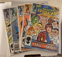 Five 1985 The Amazing Spider-Man comics, individually sleeved, with the front covers showing main characters and Spider-Man in various poses and costumes.