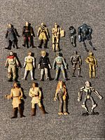Lot of 15 Star Wars action figures displayed on a gray surface, showing full-body front view of each figure.