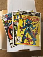 Three comic books in protective sleeves displaying the cover art and titles, showing the lot of Amazing Spider-Man issues 223, 224, 225.