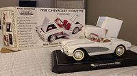 Front and left side view of the white and silver detailed 1958 Chevrolet Corvette model on display base with original box and protective white foam.