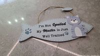 Front view of wooden fish-shaped wall art with cartoon cat and text "I'm Not Spoiled My Master Is Just Well Trained".