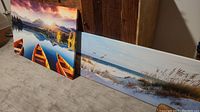 Both canvas prints leaning against wooden furniture on carpeted floor, showing general size and condition.