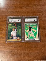 Two graded Derek Jeter baseball cards encased in slabs with grading labels showing 1993 Upper Deck #449 graded 7.5 and 1995 Topps #98 graded 9.5.