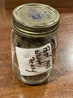 Glass jar with handwritten label stating 'Post 1940 Wheat Penny', filled with pennies, sealed with a metal lid