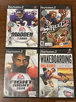 Four PlayStation 2 games: Madden NFL 2005, NFL Street 2, Fight Night 2004, Wakeboarding Unleashed with Shaun Murray, in their original cases.