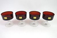 Four ruby red and clear glass sherbet or champagne short dessert glasses shown upright with gold brand labels.