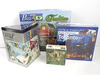 Four sealed puzzles including Heye Happy Skiing 500 piece, Puzz3D Tradition Collection 272 piece, Now & Then Toronto 1000 piece double-sided, and San Diego Zoo Koalas mini puzzle.