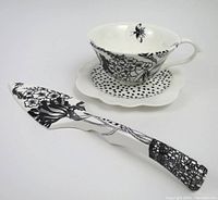 Cake server, cup, and saucer displayed with clear views of patterns and shapes