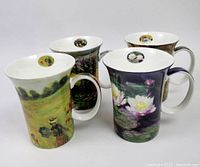 Four McIntosh Monet Classics mugs showing classic Monet impressionist artworks with water lilies and nature scenes, arranged grouped together showing exterior and handle details.