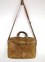 Front view of vintage leather briefcase bag with single zippered compartment and shoulder strap.