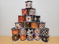 Front-facing pyramid stacked display showing 18 rolls of Halloween-themed ribbon, with assorted designs including pumpkins, bats, ghosts, and phrases.