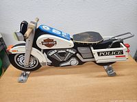 Side view of the wooden Harley Davidson police motorcycle model showing detailed paint and logos.