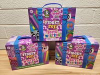 Three unopened YoYo Fun Fidget Toy Mystery Boxes stacked in a pyramid with one box on top and two below, showing front packaging.