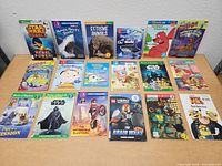 Full spread photo showing all 20 assorted kids books laid out on a flat surface, covers facing up.